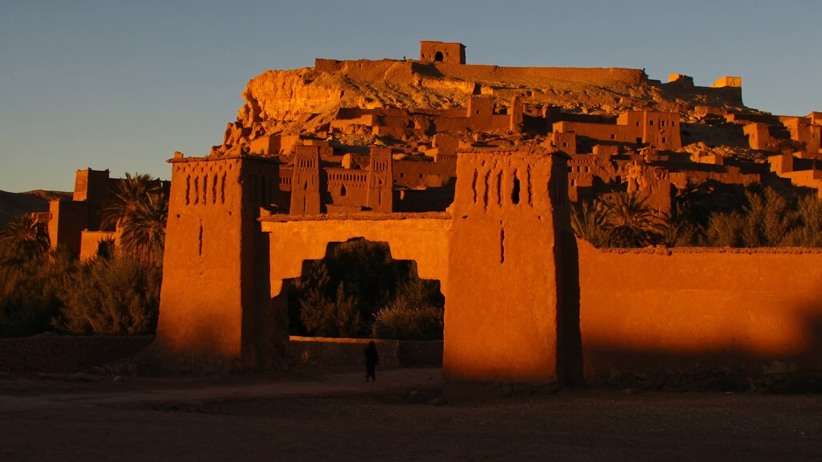 The ancient earthen towers of Ait Benhaddou kasbah glowing amber at golden hour